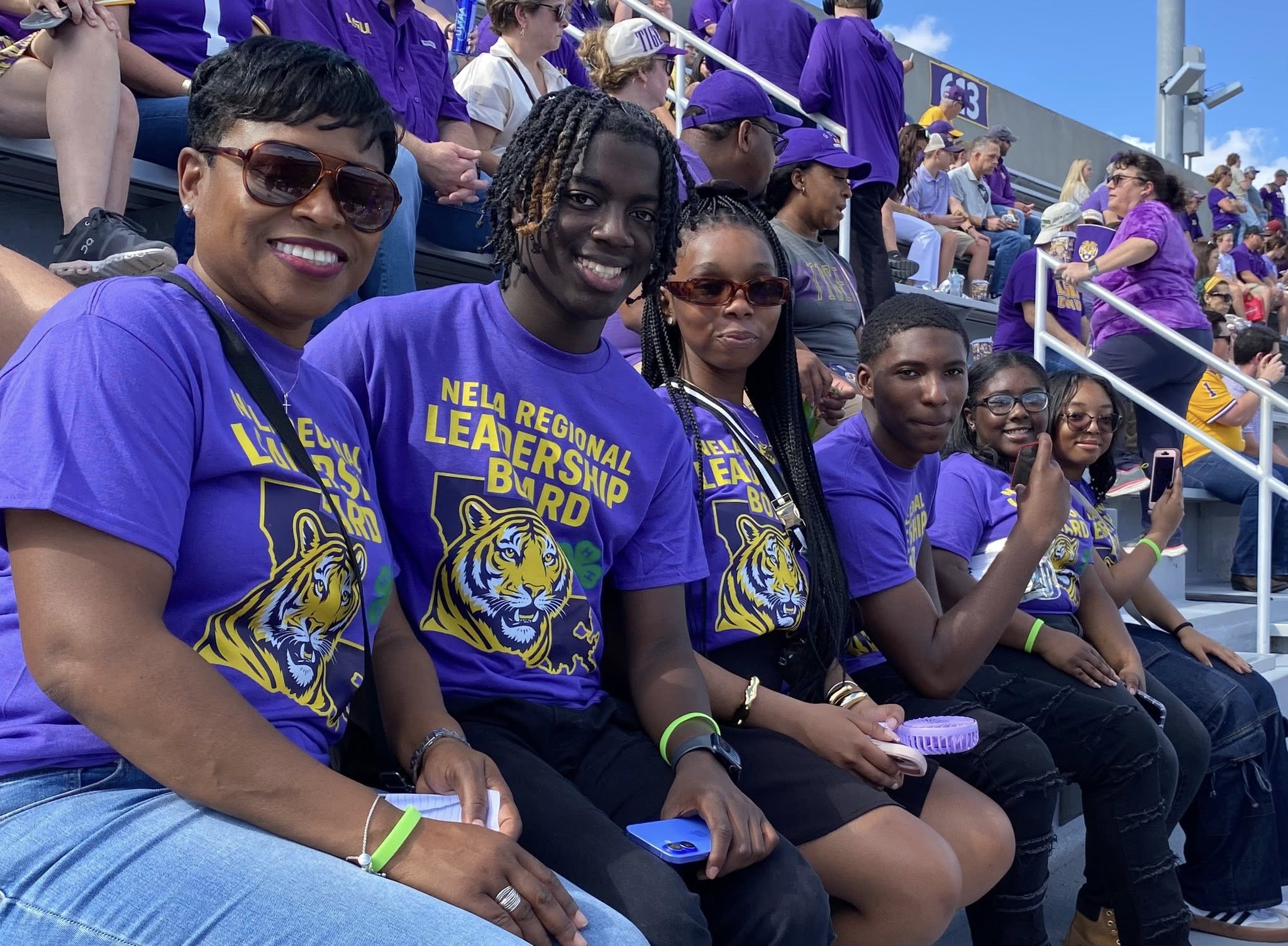 A group of people in LSU T-shirts posing for a photo.